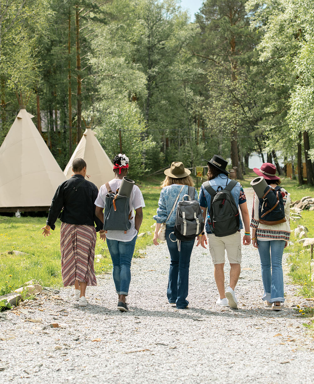 Festival campsite met vijf jongeren aan het wandelen